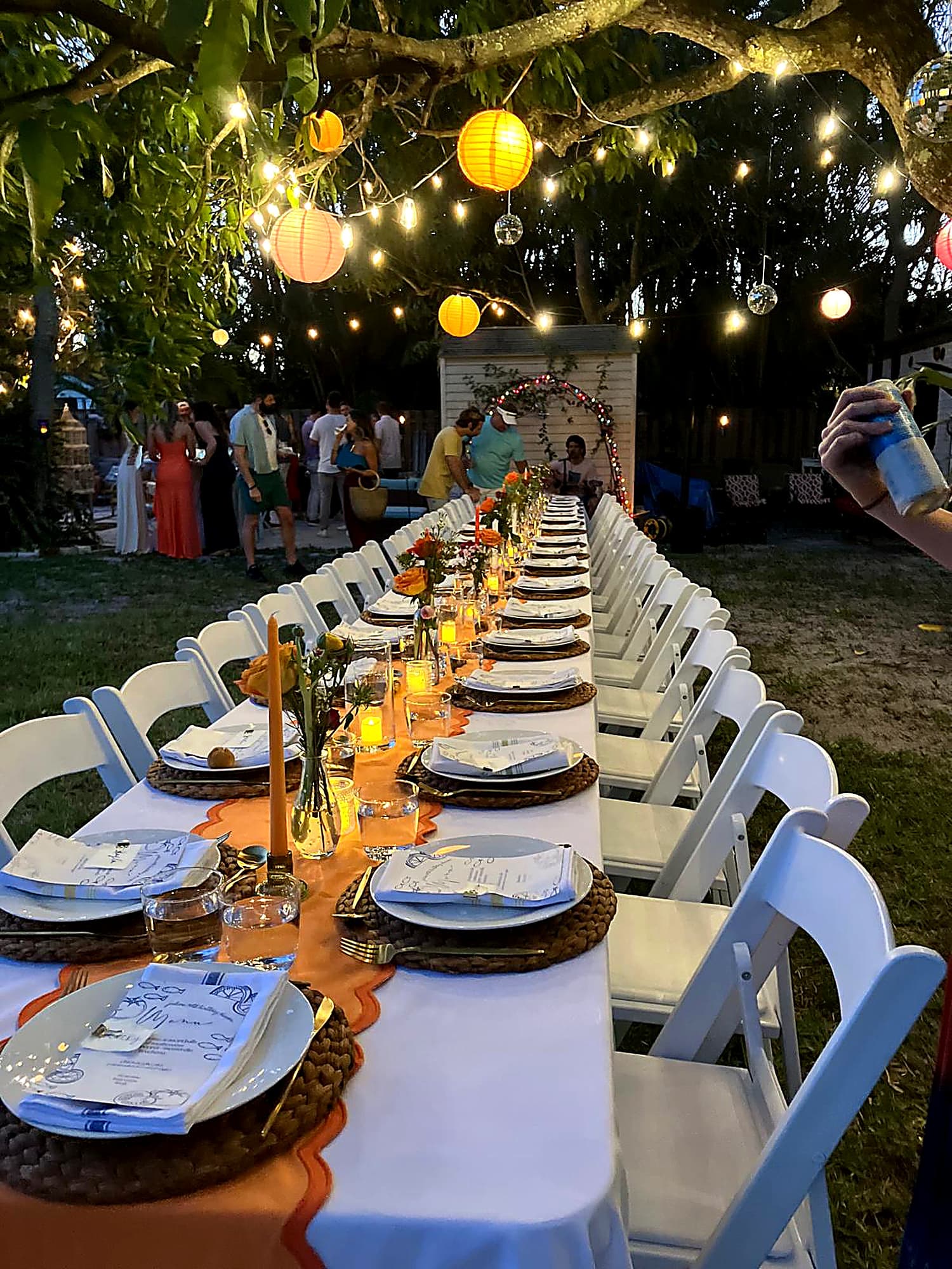 Garden dinner table glowing under lanterns