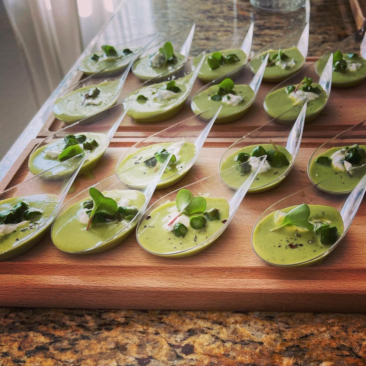 Rows of asparagus soup tasting spoons with crème fraîche