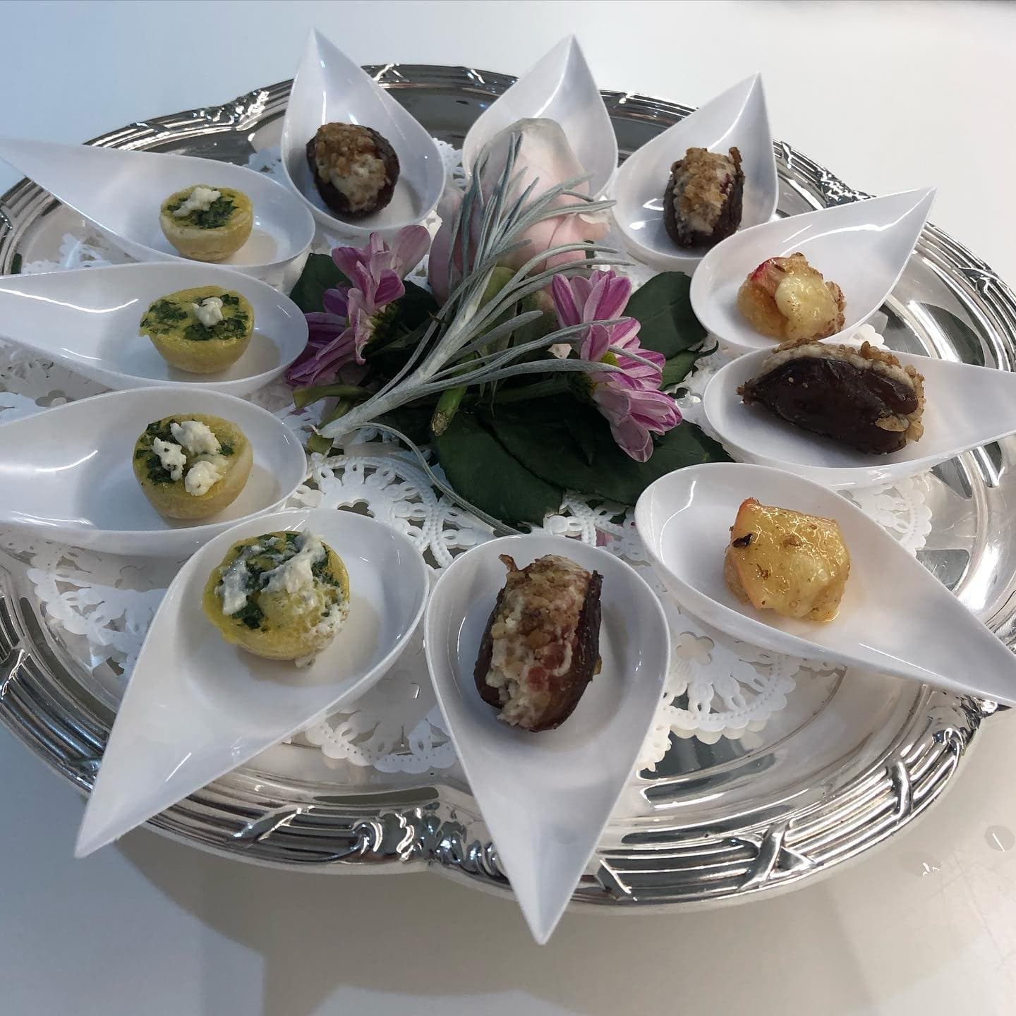 Assorted canapés arranged on a silver platter