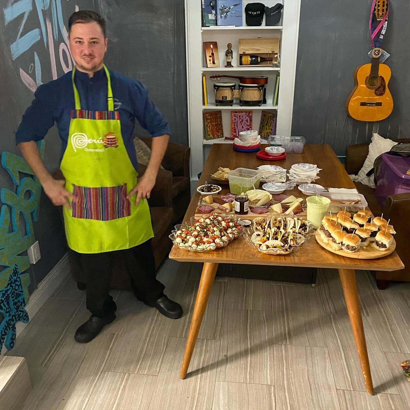 Chef Pablo in a Peru apron beside a table of appetizers