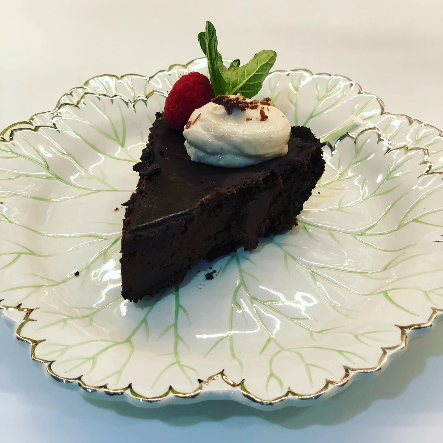 A slice of chocolate-espresso ganache tart with cream