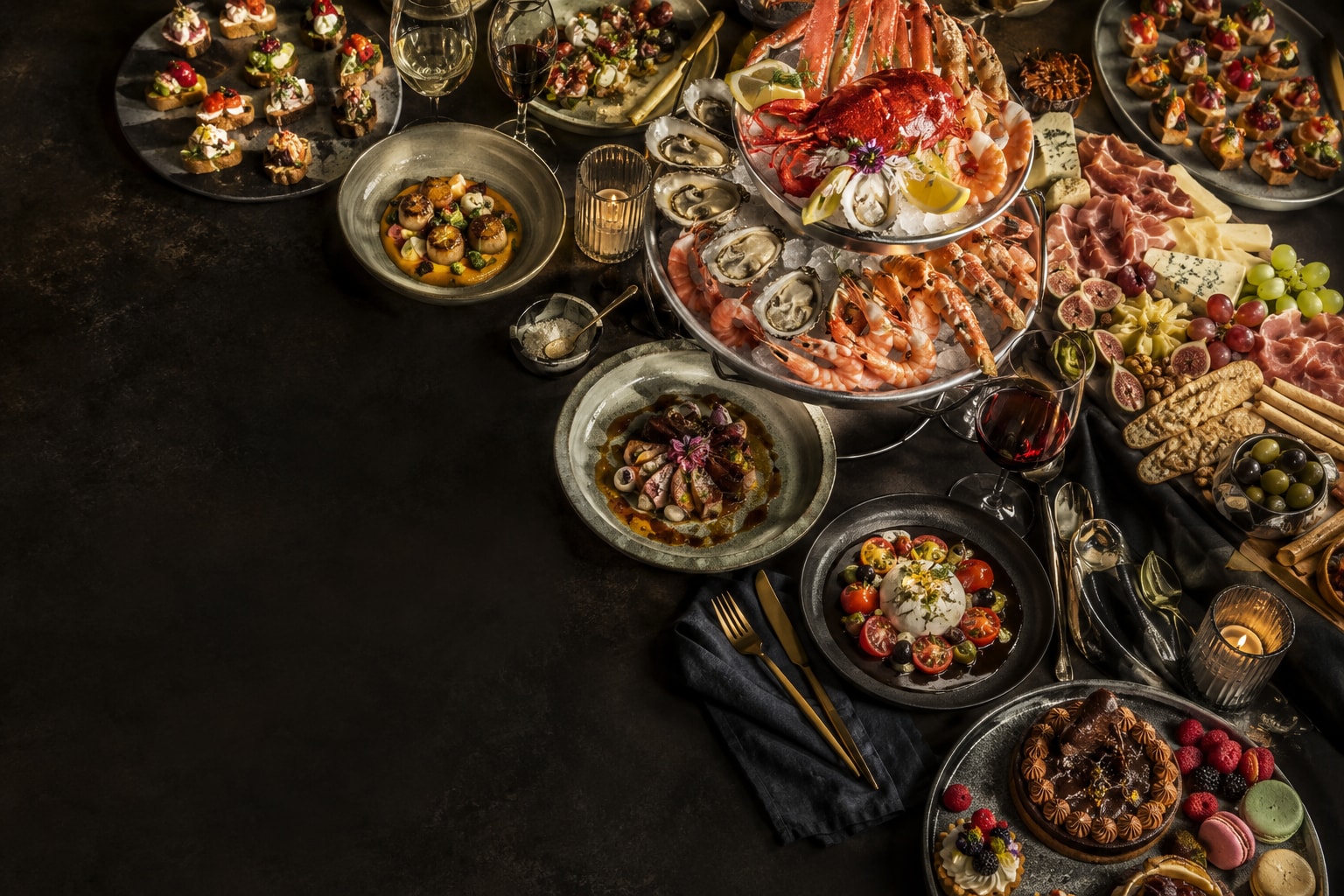 A lavish overhead banquet by Chef Pablo — a seafood tower, grazing charcuterie, colorful canapés, plated dishes, and desserts across a dark table