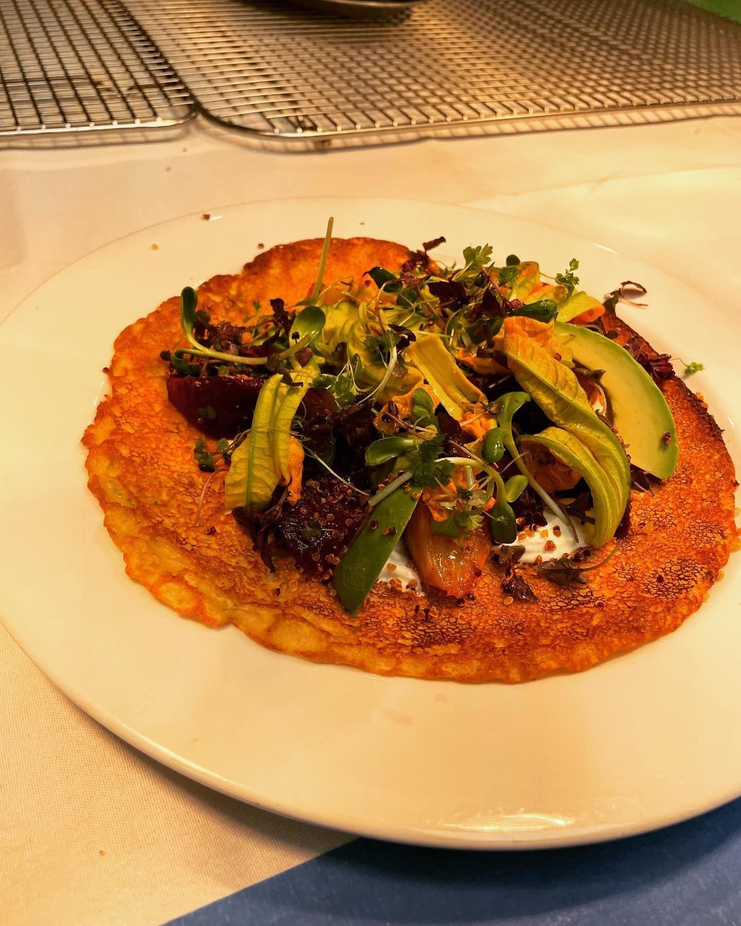 Chickpea socca crêpe topped with roasted beets and avocado