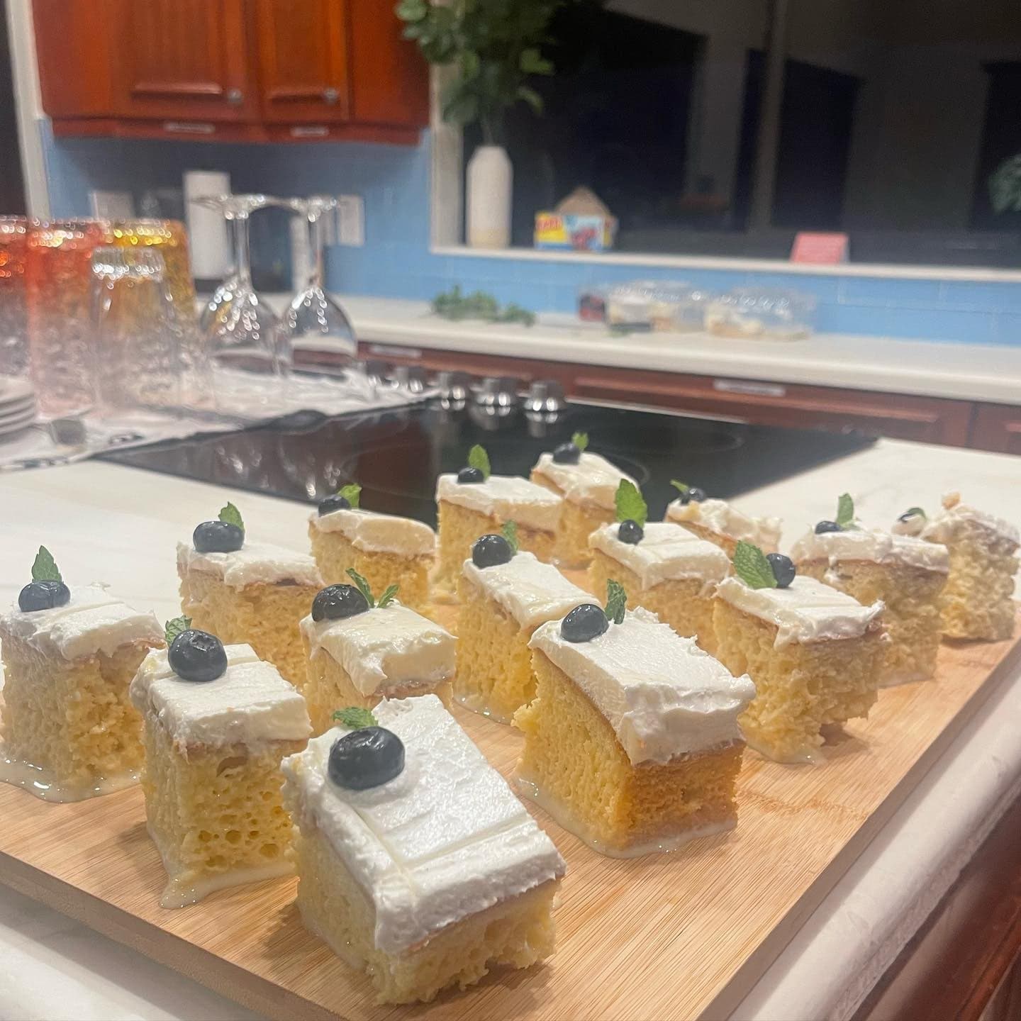 Squares of tres leches cake topped with whipped cream